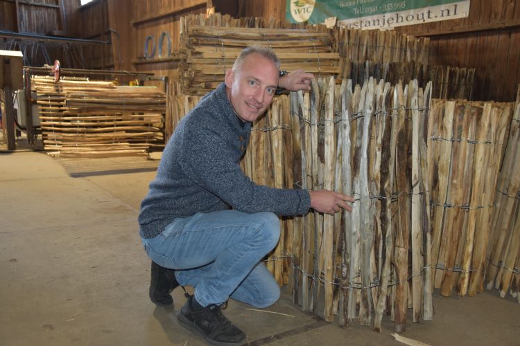 Eigenaar Willem Termaat bij een net geproduceerd, opgerold schapenhek